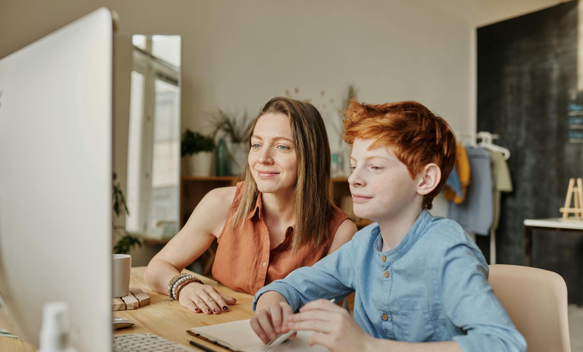 A mother and her son engaging in online learning at home, fostering education and connection.